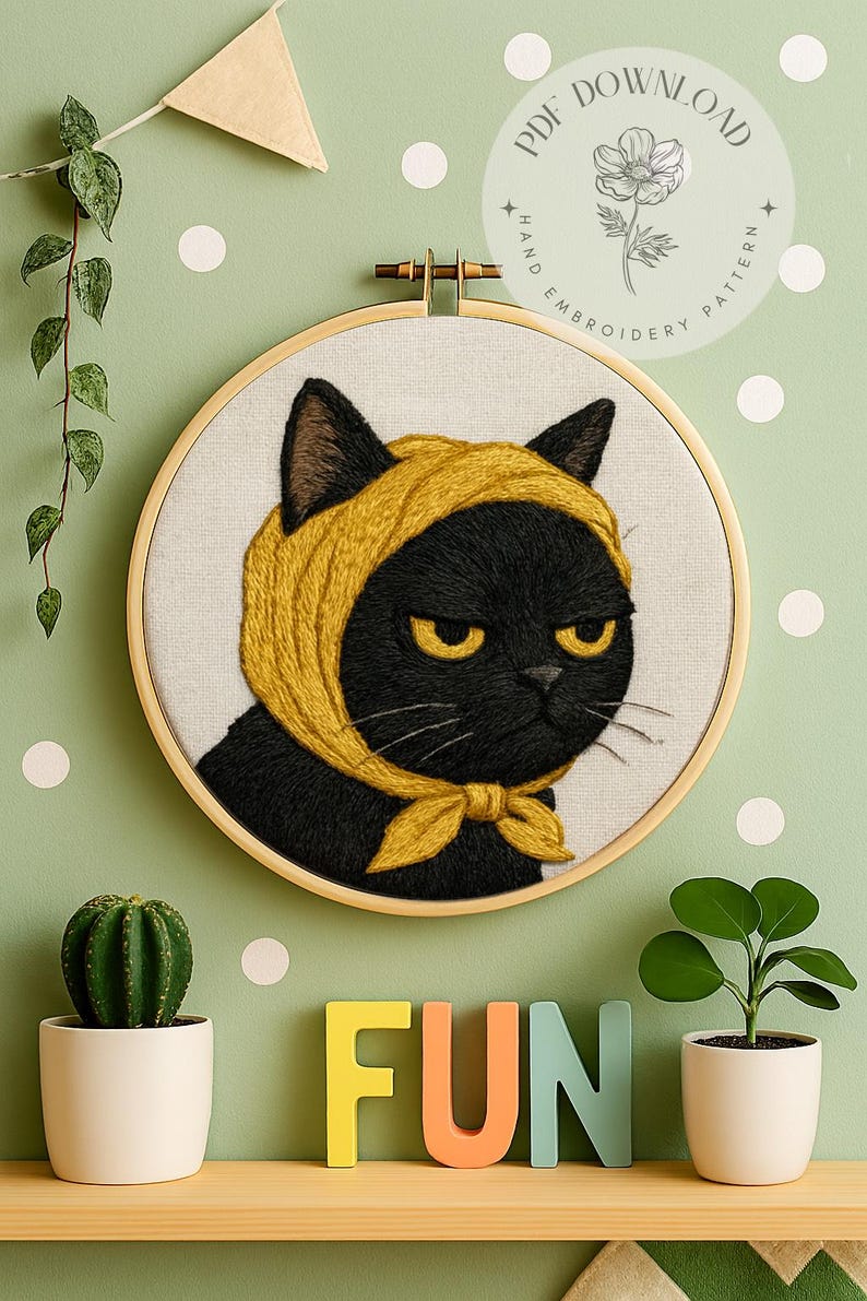 以下が含まれることがあります： 黄色いスカーフとリボンをつけた黒猫の刺繍アート。猫は黄色い目をし、不機嫌そうな表情をしています。背景は、白い水玉模様の薄緑色の壁です。「FUN」という言葉がカラフルな文字で表示されています。