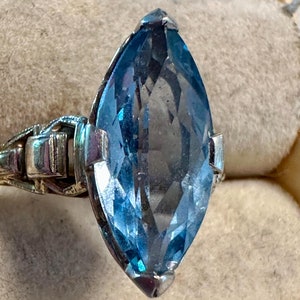 A mid century 14k gold man made sky blue faceted navette ring.  Size-4