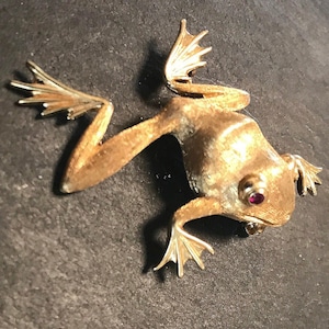 14k texturerad brosch med hoppande groda och rubinögon - fin kvalitet och nyckfull