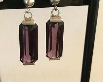 May include: A pair of silver earrings with purple rectangular stones.