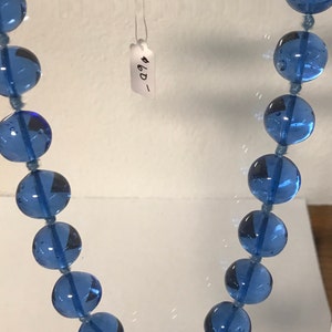 May include: A blue glass bead necklace with a price tag that says "#6D_"