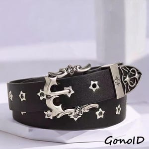 May include: Black leather belt with silver-tone metal star and anchor accents. The belt features a decorative buckle with a star design and a skull detail. The word "Gonold" is printed on the bottom right.