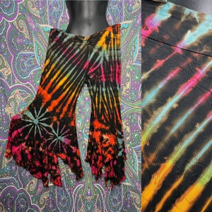 May include: Black bell bottom pants with a tie-dye pattern in shades of orange, pink, blue, and green. The pants have a wide leg and a ruffled hem.
