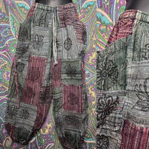 Peut inclure: Pantalon ample présentant un motif patchwork dans des tons de gris, vert et bordeaux. Le tissu affiche divers motifs floraux et botaniques imprimés en noir. Ce pantalon comprend une taille élastique avec un cordon de serrage.
