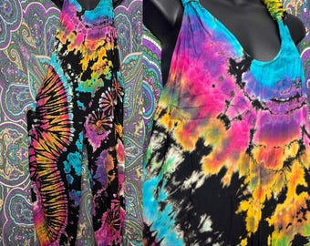 May include: A sleeveless jumpsuit featuring a vibrant tie-dye pattern in shades of black, bright pink, yellow, and turquoise. The garment has a scoop neckline and thick, gathered shoulder straps, showcasing a bold, multi-colored design.
