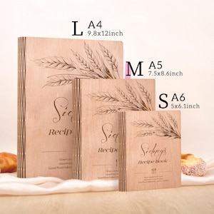 K&ouml;nnte beinhalten: Drei Kochb&uuml;cher aus Holz in den Gr&ouml;&szlig;en L, M und S. Das gr&ouml;&szlig;te ist 25x30cm, das mittlere 19x22cm und das kleinste 13x15cm gro&szlig;. Jedes Buch hat ein Weizen&auml;hren-Design und den Schriftzug "Recipe".