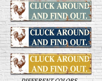 Puede incluir: Tres letreros rectangulares con un aspecto desgastado, cada uno con una ilustración de gallo y el texto "CLUCK AROUND AND FIND OUT." Los letreros son azules, azul marino y amarillos, con palabras blancas. La parte inferior de la imagen dice "DIFFERENT COLORS."