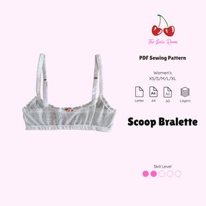 May include: A white lace bralette with thin adjustable straps and a small pink rose detail at the center. The text reads The Girls Room, PDF Sewing Pattern, Women's XS/S/M/L/XL, Letter, A4, A0, Layers, Scoop Bralette, and Skill Level with two pink dots.