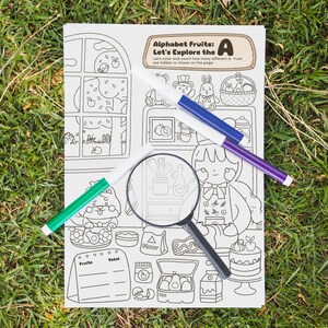 Könnte beinhalten: Eine Malbuchseite mit dem Text "Alphabet Fruits: Let's Explore the A". Die Seite zeigt Illustrationen von Früchten und einem Koch, mit grünen, blauen und lila Markern und einer Lupe.