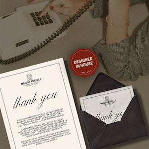 May include: An elegant stationery set featuring a thank you card and envelope, with the Maison Aurelle logo. The card and envelope are black and white, with the words "thank you" in a stylish font. A red "Designed in House" seal is also visible.