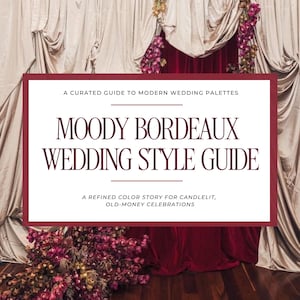 May include: A wedding style guide titled "Moody Bordeaux Wedding Style Guide" in a burgundy frame. The image features draped fabric and floral arrangements, creating a backdrop that suggests a theme of elegant, romantic weddings.
