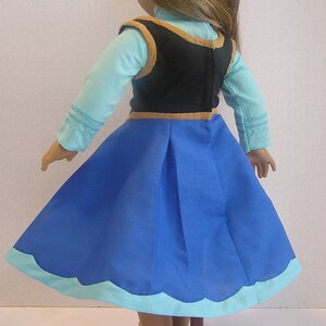 May include: A blue and light blue dress with a black vest and gold trim. The dress has a scalloped hemline.