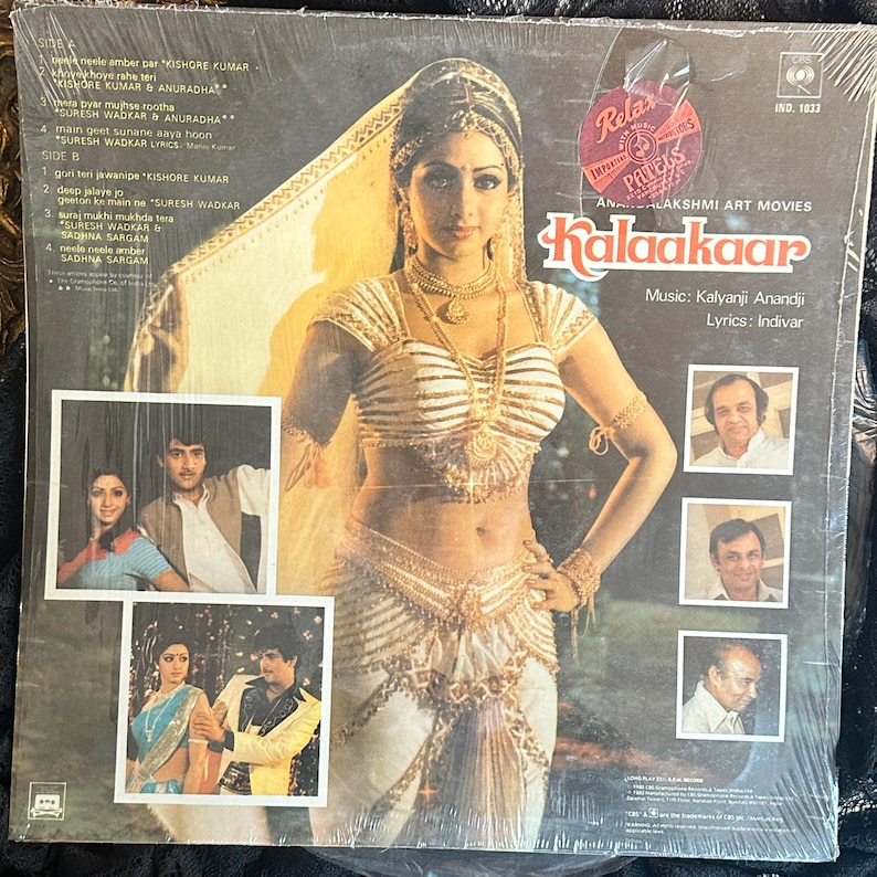 May include: Vintage vinyl record album cover for the movie "Kalaakaar." The cover features a woman in traditional Indian attire, with gold jewelry and a white and gold outfit. The album includes photos of the cast and credits.