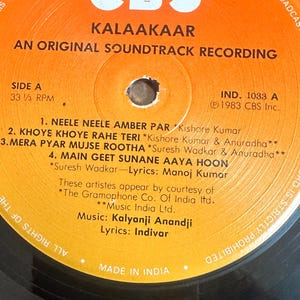 May include: A vintage vinyl record for the soundtrack "Kalaakaar" by CBS. The record label is orange with black text, listing song titles and credits. The record is a 33 1/3 RPM, made in India.