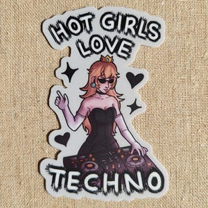 May include: A sticker featuring a cartoon illustration of a woman with peach-colored hair, wearing sunglasses and a black dress, operating DJ equipment. The text "HOT GIRLS LOVE TECHNO" is above and below the image.