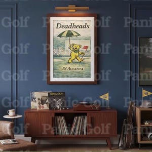 May include: A framed poster with the text "Deadheads IN AUGUSTA" features a yellow bear holding a golf flag and umbrella. The poster is displayed above a mid-century modern cabinet with vinyl records, a record player, and golf flags.