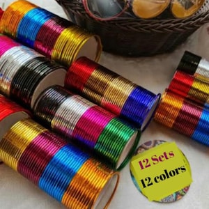May include: A collection of colorful bangles in various shades, including gold, red, pink, and blue. The bangles are arranged in sets, with a yellow tag indicating "12 Sets 12 colors."