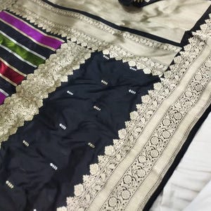 Sari kaduwa de seda katan macio e elegante banarasi com base preta clássica e pallu listrado vibrante, perfeito para festas
