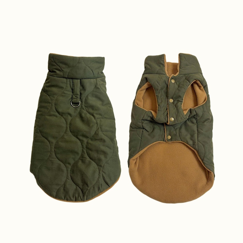 May include: Olive green quilted dog coat with a brown fleece lining. The coat has a high collar, a metal D-ring, and button closures. The coat is designed to keep dogs warm and comfortable.