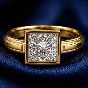May include: A gold ring featuring a square princess-cut clear gemstone set in a bezel setting. The band has a smooth, polished finish with a structured design. The ring is displayed with the text Motivone Craft visible in the corner.