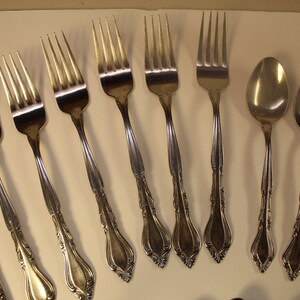 May include: A set of silverware with a decorative design. The set includes forks, spoons, and a butter knife.