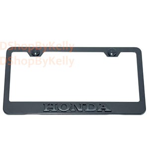 May include: A rectangular black license plate frame featuring the word HONDA embossed in raised lettering at the bottom center. The frame includes two circular mounting holes at the top corners, each fitted with a matching black screw cover cap.