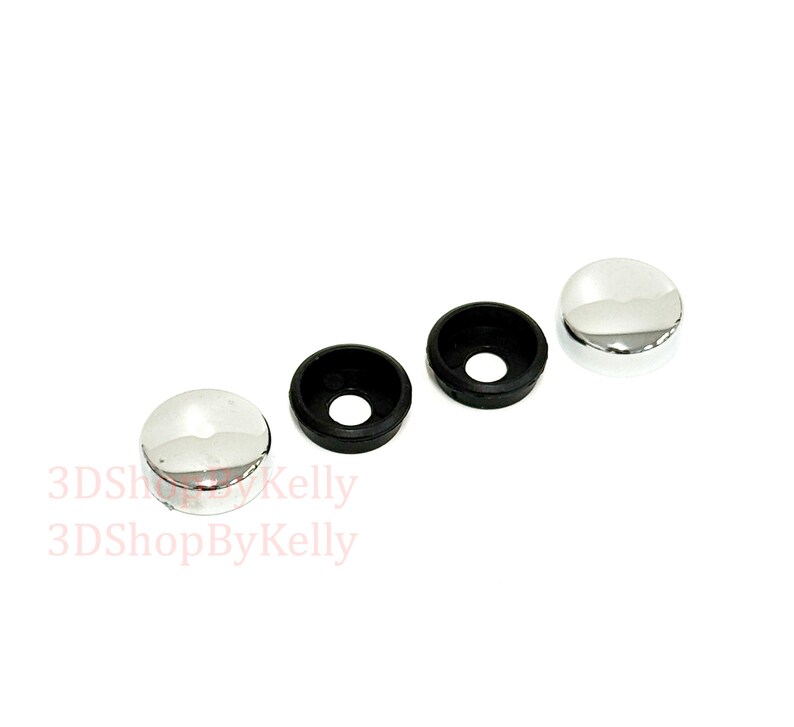 May include: Two circular chrome-finished screw covers with smooth, reflective surfaces and two corresponding black plastic washers with central holes. The text 3DShopByKelly is visible in light red lettering on the lower left side of the image.