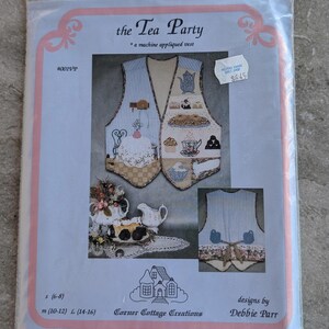 May include: A package for a machine appliqued vest pattern titled "the Tea Party." The vest design features tea party-themed appliqués, including teacups, cakes, and teapots. The pattern is by Debbie Parr and is available in sizes S (6-8), M (10-12), and L (14-16).