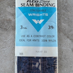 May include: Navy blue Flexi-Lace seam binding by Wrights. The package includes 3 yards of stretchable, navy blue lace trim. The packaging features a blue and white label with the text "Navy 55".