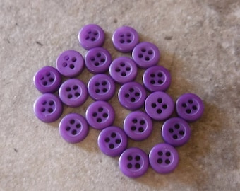May include: A collection of 20 purple plastic buttons with four holes each.