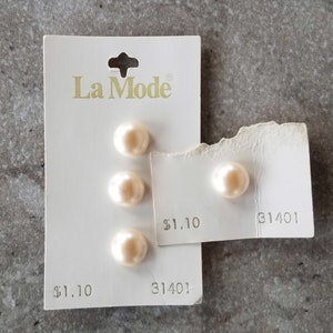 May include: A package of three white pearl buttons with the brand name "La Mode" and the product number "31401" printed on the card. The price is listed as $1.10.