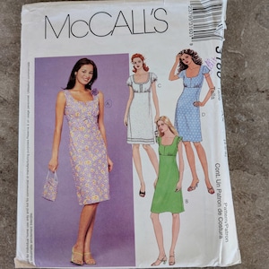 May include: A McCall's sewing pattern envelope featuring illustrations of four different dresses. The dresses include a floral print, polka dots, and solid colors. The envelope has the McCall's logo and pattern number 3100.