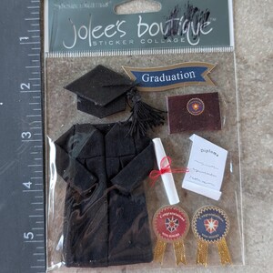 May include: A sticker collage by Jolee's Boutique featuring graduation-themed embellishments. Includes a black graduation cap, gown, diploma, and ribbons with the text "Congratulations With Honors". A banner reads "Graduation".