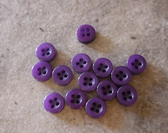 May include: A collection of 12 purple plastic buttons with four holes each.