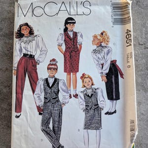 May include: A vintage McCall's sewing pattern envelope featuring illustrations of various outfits. The designs include a red polka-dot vest and skirt, a black and white checkered vest and pants, and other ensembles. The envelope is labeled "4651" and "Size 8".