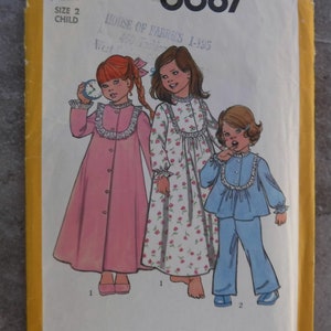 May include: Simplicity sewing pattern number 6687 for children's pajamas. The pattern includes three different styles: a pink nightgown with a lace trim, a floral print nightgown with a lace trim, and a blue pajama set with a lace trim. The pattern is for size 2 child.
