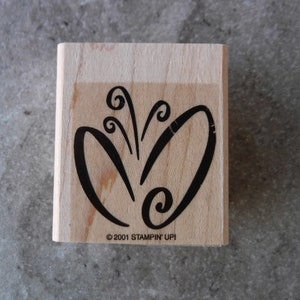 May include: A wooden stamp with a black design of a stylized butterfly with swirls. The stamp is labeled "© 2001 STAMPIN' UP!"