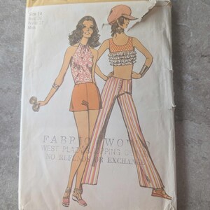 May include: Vintage Simplicity sewing pattern envelope featuring illustrations of two women in 1970s fashion. The envelope shows a halter top and shorts, and a striped top and pants. The text on the envelope reads "Fabric World".