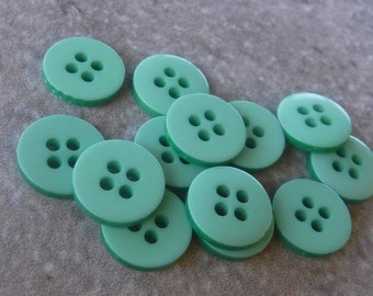 May include: A pile of 12 green plastic buttons with four holes each.