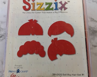 May include: A red plastic package of Sizzix die-cutter shapes for crafting. The package contains four different shapes of boy's hair. The package is labeled "Sizzix The Little Die-Cutter That Makes a Big Difference." and "38-0102 Doll Boy Hair Set #1 Actual Size on Back".
