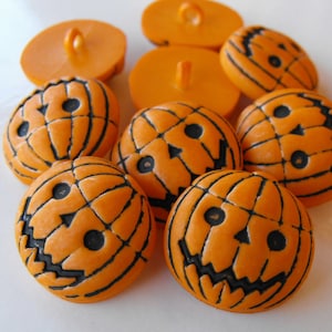 May include: A set of ten orange plastic buttons with a jack-o'-lantern design. The buttons are approximately 1 inch in diameter.