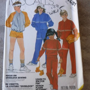 May include: A sewing pattern for a tracksuit with a focus on overlock sewing. The pattern includes instructions for sewing with overlock machines. The pattern is for sizes 8, 10, 12, 14, and 16. The pattern is from McCall's and the pattern number is 2081.