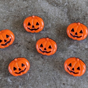 May include: Six orange pumpkin-shaped buttons with black painted faces.
