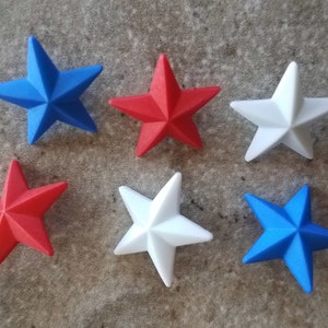 May include: Six five-pointed stars in red, white, and blue. The stars are arranged in two rows of three.