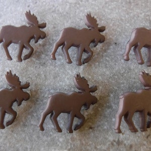 May include: Six brown moose-shaped buttons. The buttons are made of plastic and have a smooth, glossy finish.