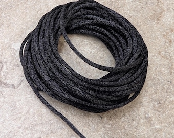 May include: A spool of black waxed cord, perfect for jewelry making, macrame, or crafts.