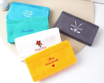 May include: A selection of personalised towels in shades of blue, teal, white, grey, and yellow. The towels feature text such as "YOUR DESIGN HERE", "Dad's Towel", "YOUR TEXT", "Mom loves sports", and "GOLF CLUB".