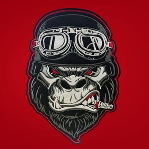 Puede incluir: Un parche bordado que muestra un gorila con casco negro y gafas blancas. El gorila tiene ojos rojos, dientes descubiertos y un cigarro en la boca. El diseño está delineado con hilo rojo y negro, mostrando un bordado detallado.