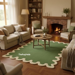 May include: A green area rug with a scalloped edge in a cream color. The rug is in a living room setting with a sofa, chairs, a coffee table, and a fireplace. The text "TheRugVeda" is visible on the rug.