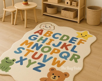 May include: A cream alphabet rug with a wavy edge, displaying colourful letters, a smiling cloud, a star, a frog, and a teddy bear. The rug is designed for a child's room.